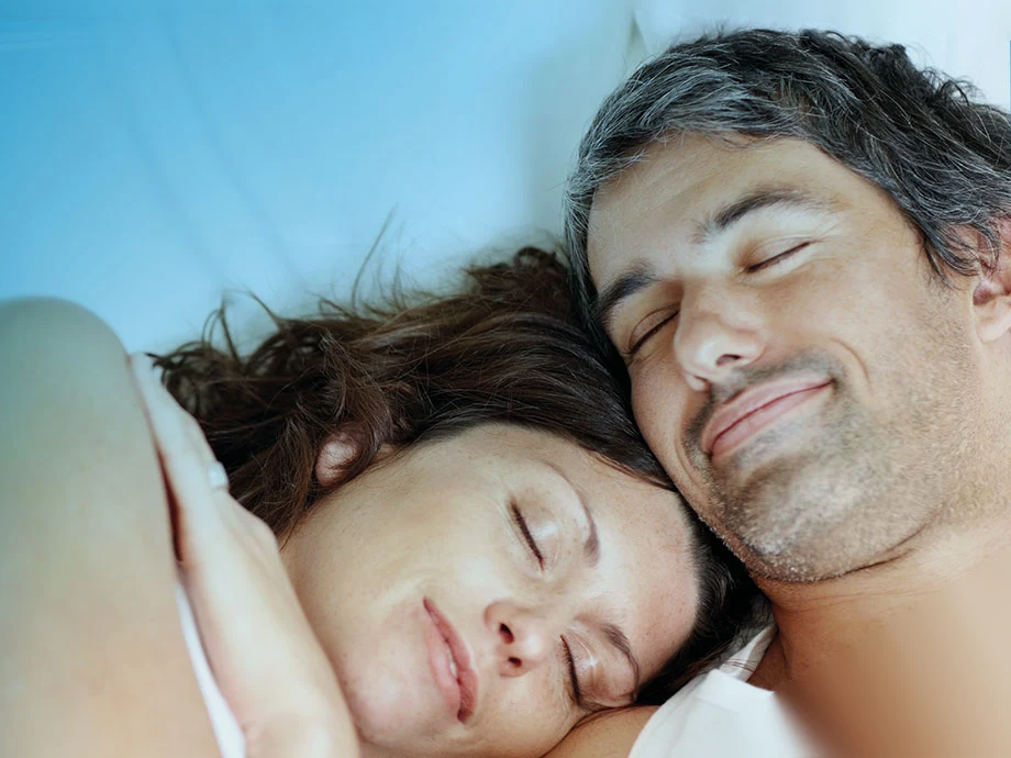 A happy couple asleep together, cheek to cheek